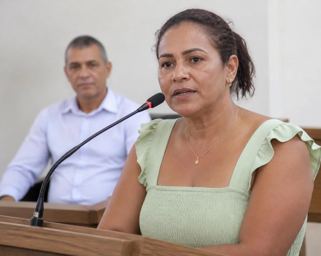 Participante ergue a mão para pedir a palavra numa mesa coberta de folhas anotadas